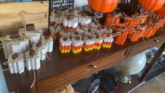 there are many candy bars on the table with orange and white candies in them