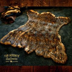 a brown and black animal skin rug next to a patch of fur on the ground