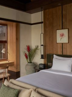 a large bed sitting in a bedroom next to a desk and chair near a window