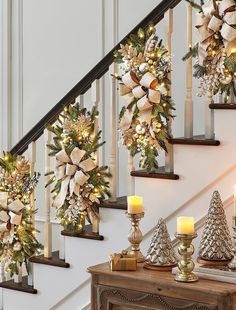 christmas decorations on the banisters and stairs with lit candles in front of them