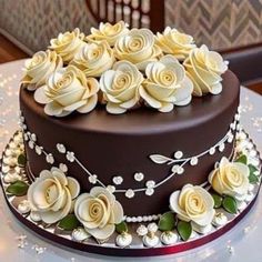 there is a chocolate cake with white flowers on the top and sides, sitting on a table