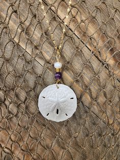 "Gorgeous, natural, handmade sand dollar necklace with genuine amethyst and freshwater pearl beads. The sand dollar is real and is painted in iridescent white pearl. It is accented with a real amethyst beads and  a freshwater pearl.  Amethyst is known for its calming power, so with this set you get the best of both worlds, a beautiful token from the sea and a gorgeous piece of the earth to compliment it. The pendant (approximately 1.5\" across) is set on an 18\", anti-tarnish stainless steel gol Sand Dollar Jewelry, Seashell Necklace Diy, Sand Dollar Craft, Fresh Water Pearl Beads, Shell Accessories, Sea Shell Jewelry, Dollar Necklace, Sand Dollar Necklace, Pearl Amethyst