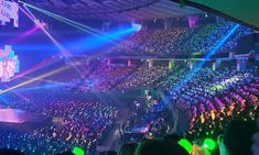 a large group of people at a concert in front of an audience with bright lights