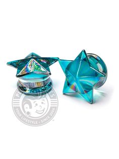 two blue glass objects sitting next to each other on a white surface with a star in the middle