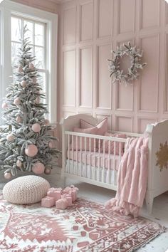 a baby's room decorated in pink and white with a christmas tree on the wall