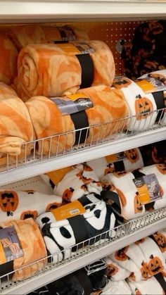 several rolls of bread wrapped in orange and black pumpkins are on display at a store