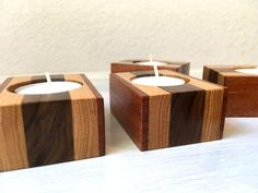 three wooden candle holders sitting on top of a white table next to eachother