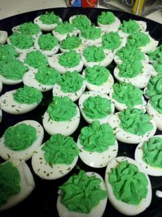 green frosted cupcakes sitting on top of a black plate