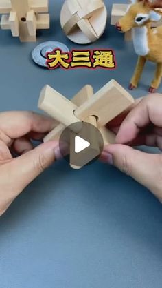 someone is making a wooden toy with their hands