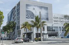 a large building on the corner of a street with palm trees in front of it