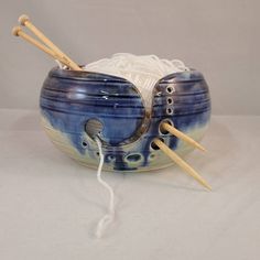 two knitting needles and yarn in a bowl