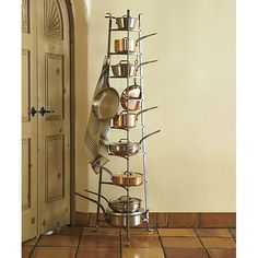 a stack of pots and pans on a rack in front of a door with a doorway