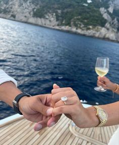 two people holding hands while on a boat