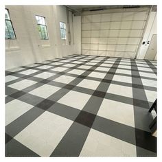 an empty garage with black and white checkered flooring