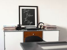 a record player sitting on top of a desk next to a black sign that says ladies & primps live