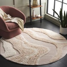 a living room with a pink chair and rug on the floor next to a window