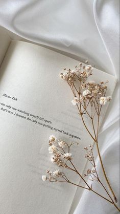 an open book with some flowers on it