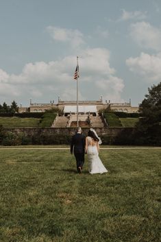 a bride and groom walking in front of the white house with an american flag on it