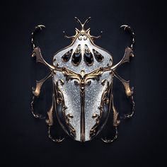 an intricately designed gold and silver object on a black background