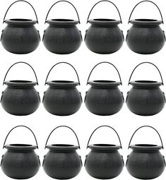 twelve black cast iron pots with handles on each side and one empty pot in the middle