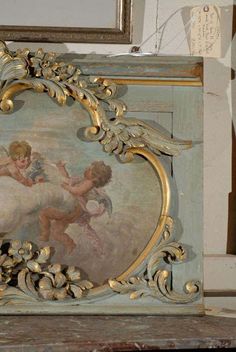 an ornate painting on the side of a wooden box with gold trimming and cherubs