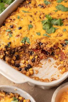 a casserole dish filled with mexican food and garnished with cilantro