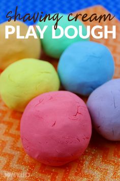 colorful play dough sitting in a pile on top of an orange towel with the words shaving cream play dough