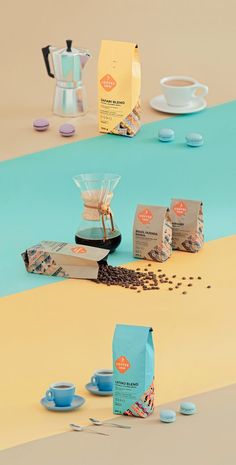 an assortment of teas, coffee bags and cups on a table with blue and yellow stripes