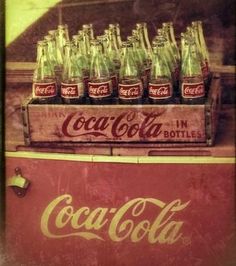 an old coca - cola cooler is full of coke bottles