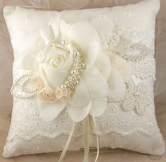 a white flower and pearl beaded ring pillow