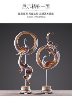 two metal sculptures on top of each other with words written in english and chinese characters