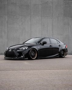 a black car parked in front of a wall