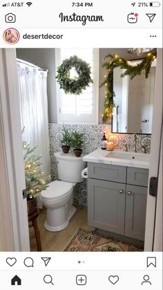 a bathroom decorated for christmas with wreaths on the window sill, toilet and sink