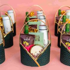 four baskets filled with different types of food and condiments on top of a pink surface