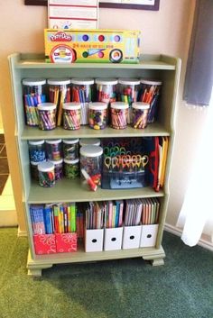 a book shelf filled with lots of books and crafting supplies on top of it