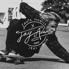 a young man riding a skateboard down the side of a street next to a christmas tree