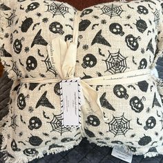 a white pillow with black skulls and bats on it