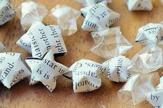 several white origami stars on a wooden table with words written in black and white