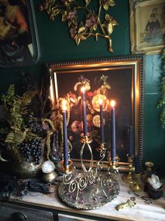 a table with some candles on it and other items in front of the wall behind it