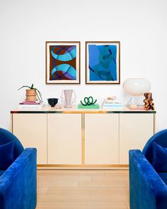 two blue chairs sitting next to each other on top of a hard wood floored floor