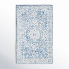 a blue and white rug hanging on the wall