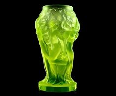 a green glass vase sitting on top of a table