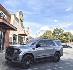 a silver suv parked in front of a store