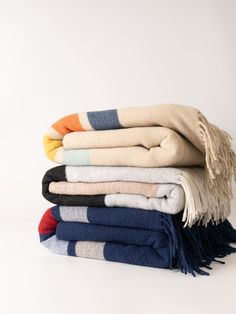 a stack of towels folded on top of each other in different colors and patterns,