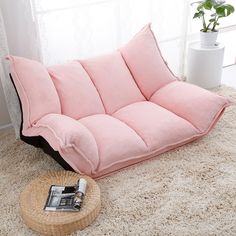 a pink futon couch sitting on top of a rug