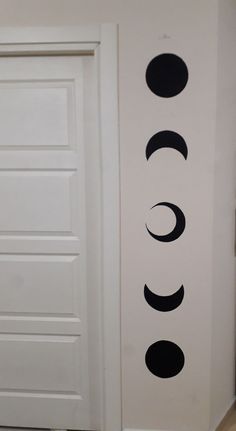 the door is open and there are three circles painted on the wall next to it