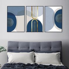 two paintings on the wall above a bed in a room with a blue and white bedspread