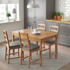 a wooden table with four chairs and a bowl on it