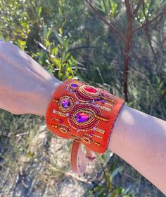 This orange velvet cuff is perfect for those who wants to add a bit of personality to their look. If you look for something unique, this eye catching one of kind jewelry is exactly for you!  Handmade unique design cuff is embellished with crystals shaped into geometric ornaments.  Bracelet is finished with a soft material - ultrasuede that is pleasant and comfortable to wear. Bracelet is adjustable, it is fastened with velvet ribbon. Main color is orange with fucsia, gold, blue, orange, purple, green accents. The actual colors may differ slightly from the one you see on your monitor screen, as it depends on the specific monitor settings. 🎁Jewelry comes in a beautiful box and is ready for gift giving. READY TO SHIP!   💎Materials:  velvet, crystals, glass beads Back side - ultrasuede. 💎Di Beaded Cuff Bracelet For Party, Handmade Orange Beaded Bracelets For Party, Handmade Wearable Art Bracelets For Party, Handmade Wearable Art Bracelet For Party, Luxury Orange Jeweled Jewelry As Gift, Bohemian Adjustable Embellished Jewelry, Orange Jeweled Jewelry As Gift, Orange Jeweled Jewelry For Gift, Elegant Embroidered Jewelry For Festival