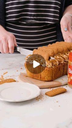 a person cutting into a cake on top of a white table next to orange juice